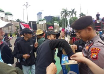 Aksi Simpatik, Polisi Bagikan Air Mineral dan Roti kepada Buruh di Depan DPR/MPR